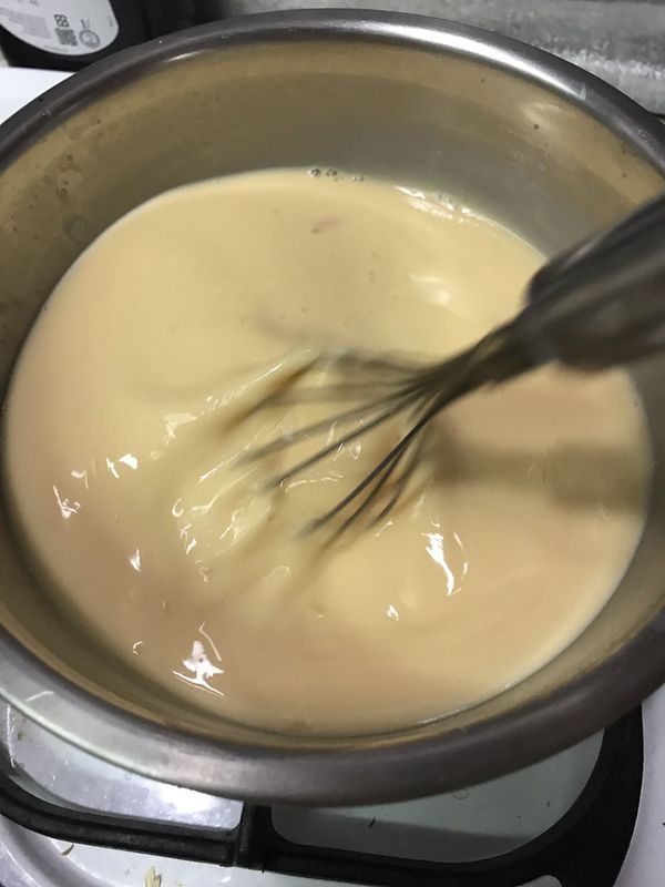 鮮奶+糖+奶粉用瓦斯爐加熱至微溫(不燙手的溫度)糖融化即可熄火，慢慢一邊攪拌一邊加入蛋液中