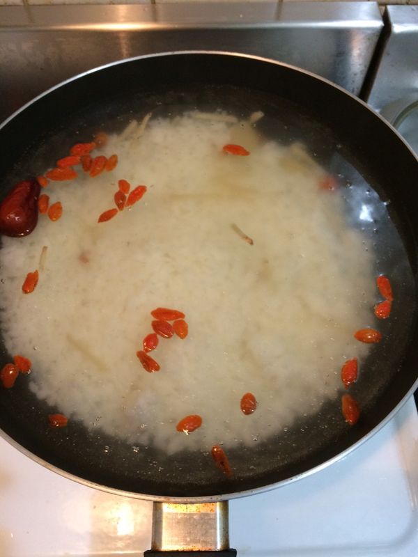 水滾後，將當歸，枸杞，紅棗，薑絲及飯都放入鍋內，水滾後，調至小火熬煮15分鐘