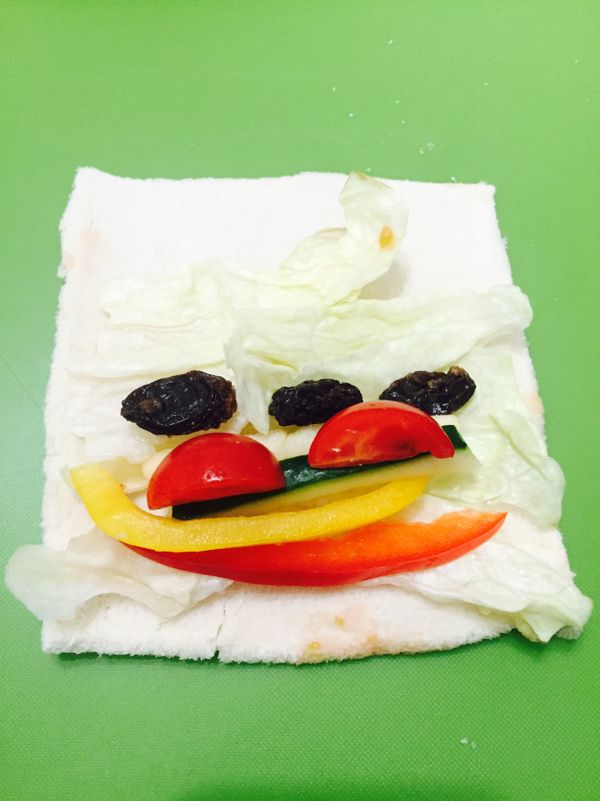 吐司去邊壓扁，依序放上生菜、彩椒、小黃瓜、蘋果、番茄、葡萄乾。
捲起後斜切。