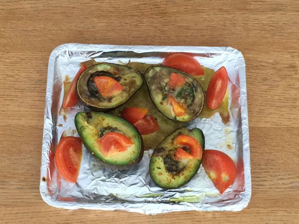 將由蕃茄切對半，再對半切開，灑在烤盤中，在牛油果上再灑上適量的辣椒碎、玫瑰鹽、薑黃粉、黑椒粉和蒜蓉。灑上橄欖油。