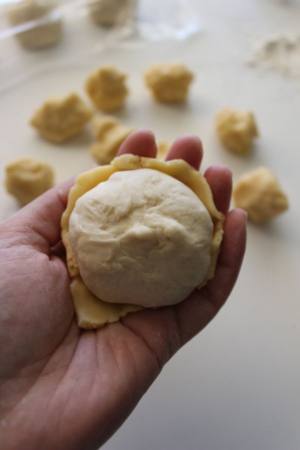 左手放菠蘿皮~右手拿麵糰~將菠蘿皮包好