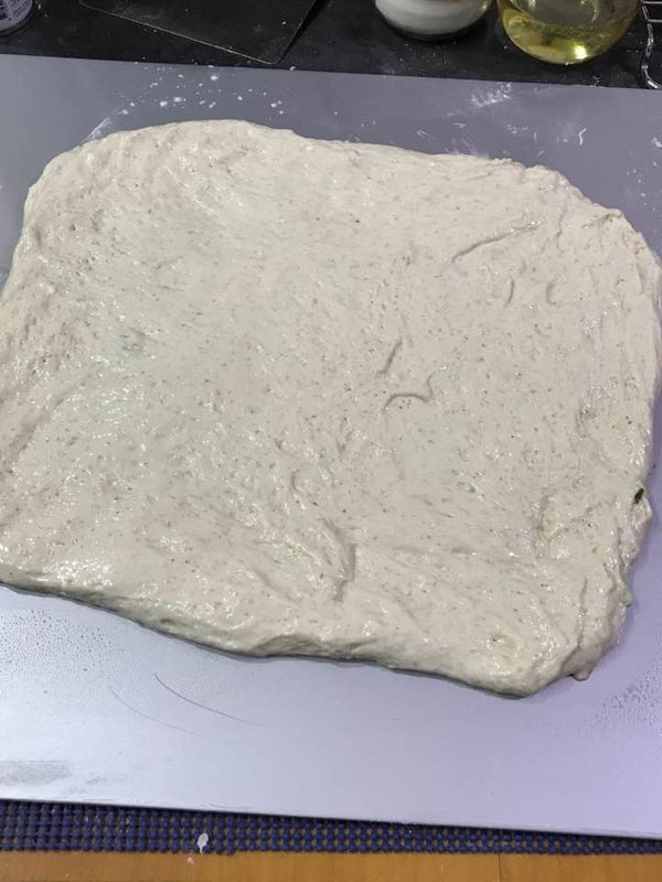 將麵團擀成大約長寛各45公分左右的正方型.撒上少許鹽及白胡椒,用手或擀麵棍略壓讓鹽及白胡椒吃進麵團中.表面用手或刮刀抺上一大匙油.