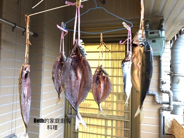 將繩子穿過魚眼綁在衣架上，在陽台風乾一夜，（夏天製作要包網子防蚊蠅），約7小時左右，魚肉顏色會變深紅，魚肉摸起來沒水分有彈性即可，不要曬到太陽，以免魚肉脂肪被曬乾