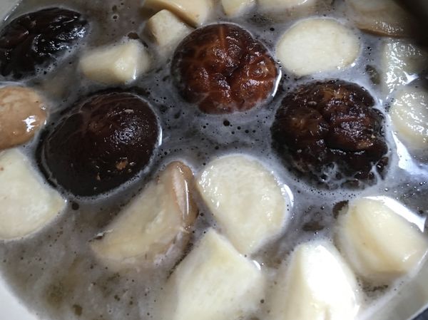 把去皮棒棒雞腿、泡軟的香菇、香菇水、薑片放進鍋中，加水和一些米酒煮三十分鐘