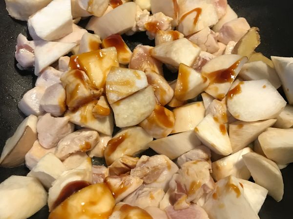 雞丁差不多每面都反白後加入杏鮑菇塊，拌炒一下再加入米酒與醬油膏。