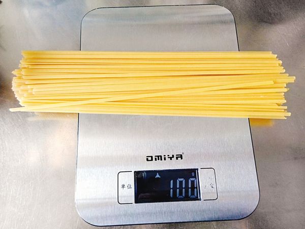 量好一人份義大利麵，約100g。