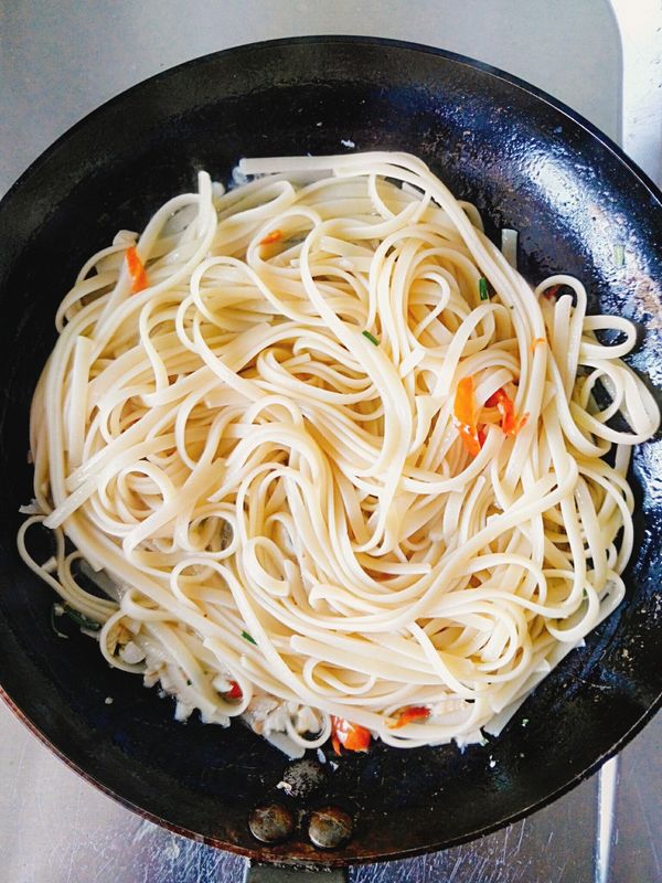 接著加入義大利麵，中火快速翻拌，煮至湯汁被麵條吸收9.5成。
關火，盛盤，淋上少許橄欖油，盤子邊灑上少許黑胡椒粒，完成。