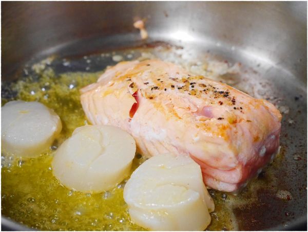 取一個鍋子，先加入奶油後再放入鮭魚及干貝煎到上色