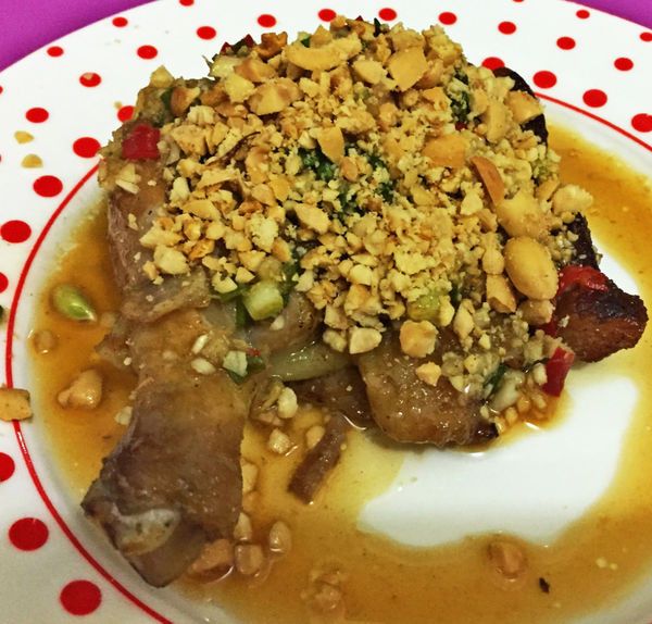 4.把花生放在保鮮薄中敲碎。雞腿起鍋後，淋上椒麻醬再鋪上蒜頭碎就完成了。