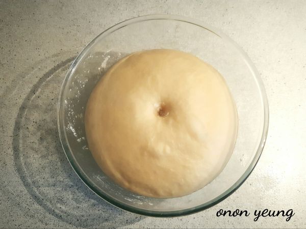 接下來進行揉麵和甩打動作，至表面光滑有韌性（注意不同品牌的粉吸水不一樣，要是太濕可灑上粉搓揉，太乾則灑水搓揉）。然後，放進底部已經搽上食用油的容器裡發酵一個小時。可以在烤箱裡放一杯熱水，把裝有麵糰的容器放進烤箱裡進行發酵過程。