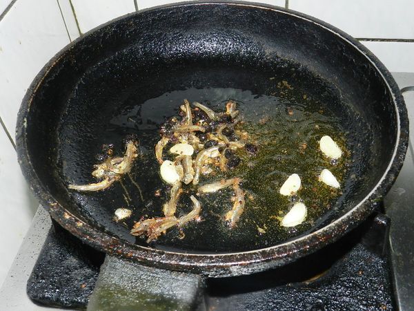 起一油鍋，將大蒜還有豆豉魚干下鍋爆香