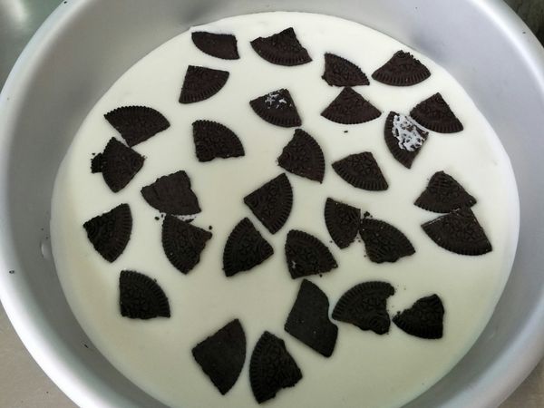 合體囉！
取出餅乾底，先倒入1/3的奶油乳酪液，平均放進oreo去餡餅乾（一片分4等份）再倒入剩下的乳酪液（建議慢慢倒，因為一下倒太多排好的餅乾會被沖到邊邊），倒完後抹平表面，於桌面輕摔幾下把空氣震出，就能冰冷藏囉！