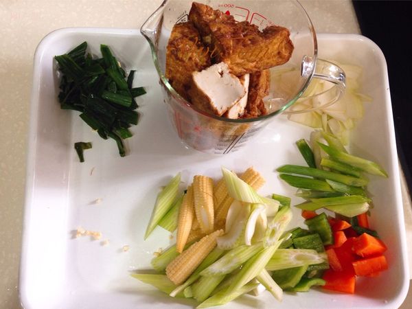 油豆腐先切一半後放滾水燙過，去掉多餘的油和油耗味，完成後撈起備用