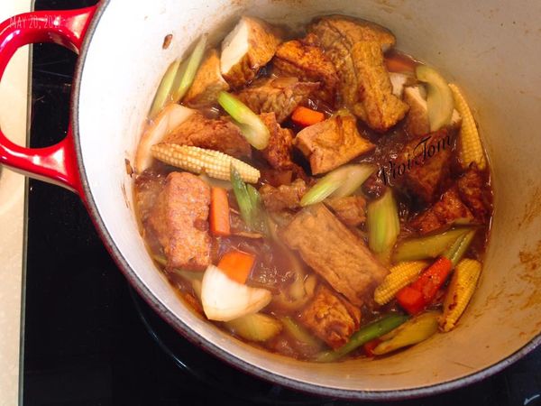 加入油豆腐，和醬汁都攪拌均勻後加入水，蓋上鍋蓋悶煮約15-25分鐘，看豆腐的入味狀況